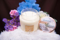 a candle is sitting on top of a furry blanket with flowers