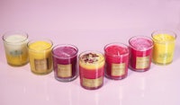 a group of colored candles in a row on a pink background