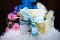 a gift box with a blue ribbon tied around it
