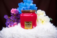 a red candle surrounded by flowers and fur