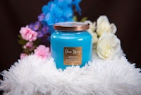 a jar of blue candle with flowers on it