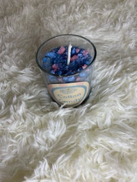 a blue and white candle on a white fur rug